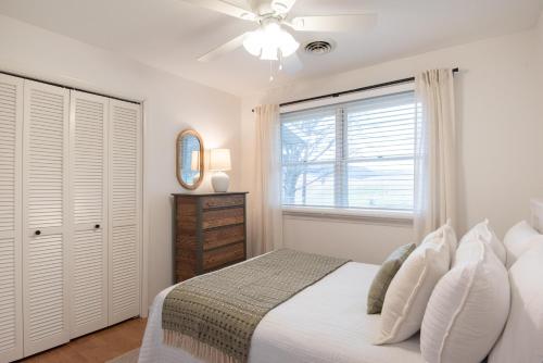 a white bedroom with a bed and a window at Inglewood Cottage 
