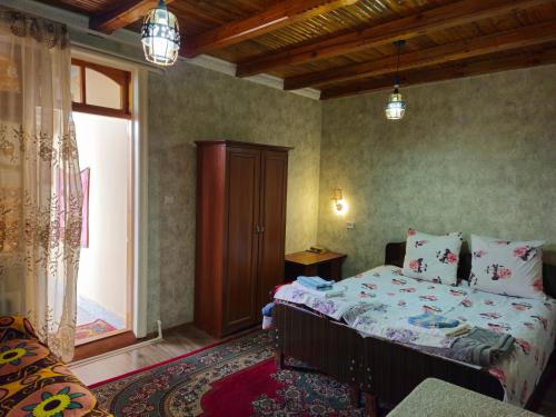 um quarto com uma cama e uma grande janela em B&B Bahodir em Samarkand