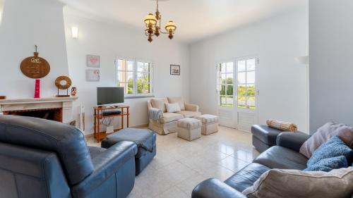 a living room with blue couches and a fireplace at Sunny & Calm 4 BDR House W/ Pool by Lovelystay in Santo Estêvão