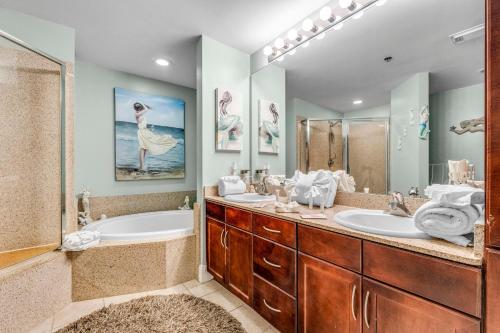 a bathroom with two sinks and a tub and a shower at Laketown Wharf 1331 in Panama City Beach