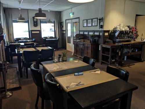 a dining room with tables and chairs in a restaurant at Hotel Restaurant Roerdalen in Posterholt