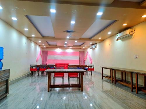 JIMS GATEWAY HOTEL AND RESTAURANT في رامناجار: غرفة طعام مع طاولات وكراسي حمراء