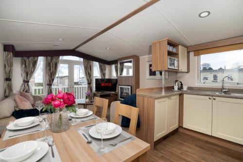 a kitchen and living room with a table and a kitchen and a dining room at CALI - 3Bed - Static Caravan in Port Seton