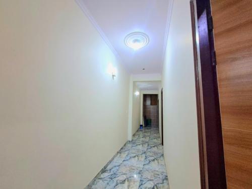 JIMS GATEWAY HOTEL AND RESTAURANT في رامناجار: ممر فارغ مع ضوء في السقف