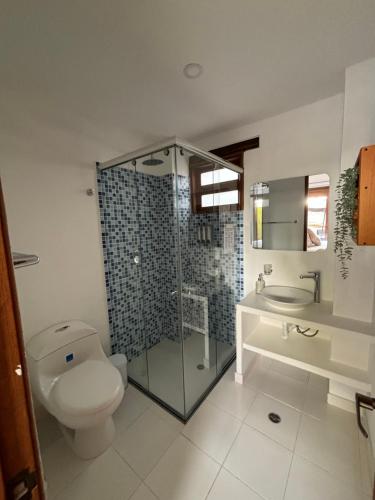 a bathroom with a toilet and a shower and a sink at Hotel El Embrujo in Villa de Leyva
