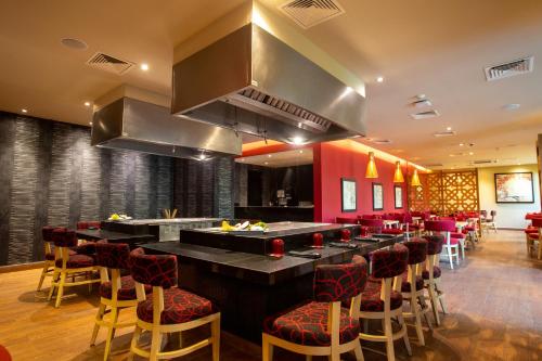 a restaurant with a bar with chairs and a kitchen at Occidental Nuevo Vallarta - All Inclusive in Nuevo Vallarta 
