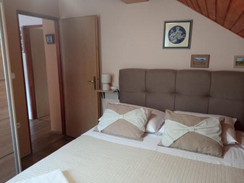 ein Schlafzimmer mit einem Bett mit zwei Kissen darauf in der Unterkunft Ruža in Skradin