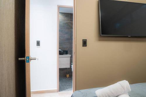 a bedroom with a flat screen tv on the wall at Apartamento en provenza mas desayuno mas Jacuzzi in Medellín