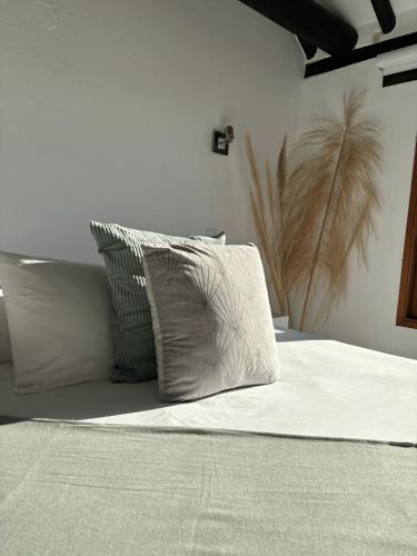 a bed with four pillows on top of it at Hotel El Embrujo in Villa de Leyva
