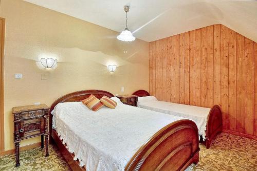 1 Schlafzimmer mit 2 Betten und einer Holzwand in der Unterkunft Appartement de 2 chambres a Juncalas in Juncalas