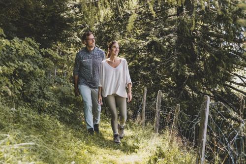 a man and a woman walking down a path at Seehotel Jägerwirt in Turracher Hohe