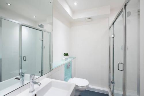 a bathroom with a toilet and a sink and a shower at Hoxton Square - Urban Haven in London