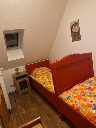 Kleines Zimmer mit 2 Betten und einem TV in der Unterkunft Neulandhof Spöring in Walsrode