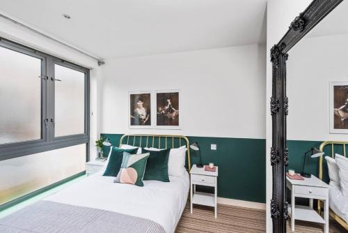 een slaapkamer met groene en witte muren en een bed bij Hoxton Square - Urban Haven in Londen