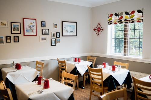 a dining room with two tables and a window at Red Mullions Guest House in Oxford