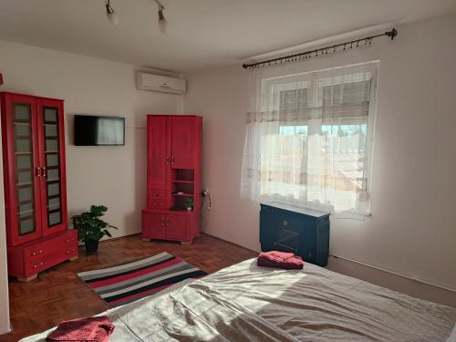 a bedroom with a bed and a red cabinet at Szaffi apartman in Hajdúszoboszló