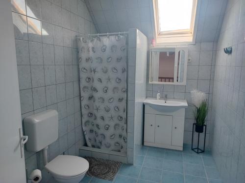 y baño con ducha, aseo y lavamanos. en Szaffi apartman en Hajdúszoboszló