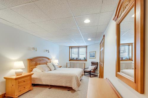 Schlafzimmer mit einem Bett, einem Schreibtisch und einem Spiegel in der Unterkunft Ski-In Resort Family Condo with Deck at Jay Peak! in Jay