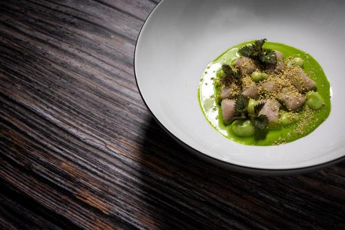 a plate of food with broccoli and meat on a table at Boutique Hotel Sunrose 7 - Gourmet & SPA in Bohinj