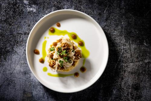 a white plate with food on a table at Boutique Hotel Sunrose 7 - Gourmet & SPA in Bohinj