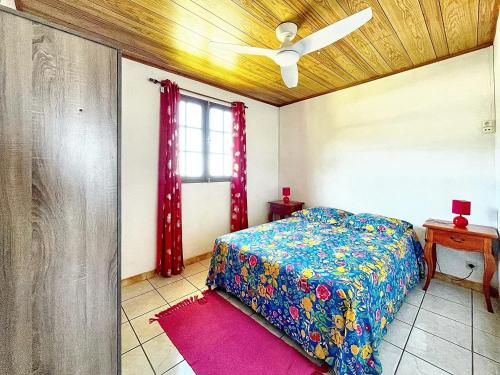1 dormitorio con 1 cama y ventilador de techo en Maison de 3 chambres avec vue sur la mer terrasse amenagee et wifi a Saint Leu, en Saint-Leu