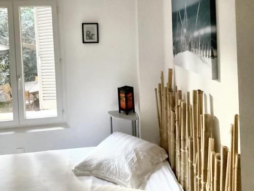 um quarto branco com uma cama e uma janela em Appartement de 3 chambres avec hammam jardin clos et wifi a Aix en Provence em Aix-en-Provence