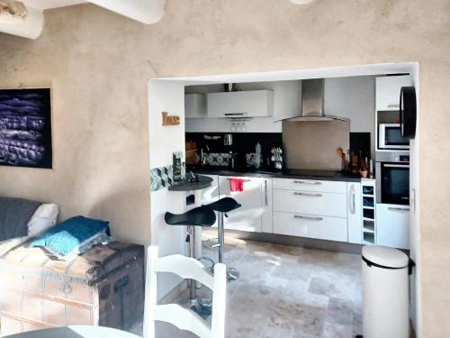 uma cozinha com armários brancos e um banco de bar em Appartement de 3 chambres avec hammam jardin clos et wifi a Aix en Provence em Aix-en-Provence