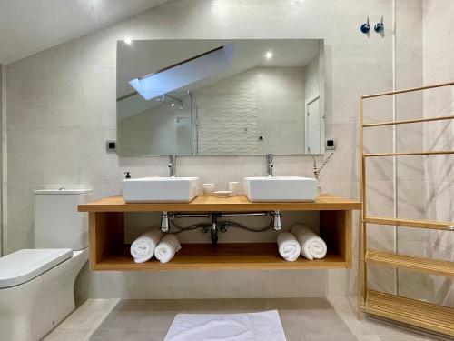 a bathroom with two sinks and a mirror at Villa Gratal in Igriés