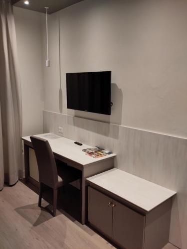 a desk with a chair and a tv on a wall at Confidence Hotel Europa in Cento