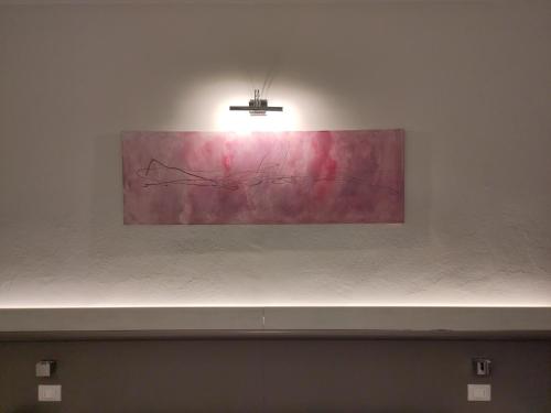 a painting on a white wall with a light on it at Confidence Hotel Europa in Cento
