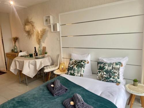 - une chambre avec un lit avec des oreillers et une table dans l'établissement Studio Blue Horizon vue mer, à Guidel-Plage