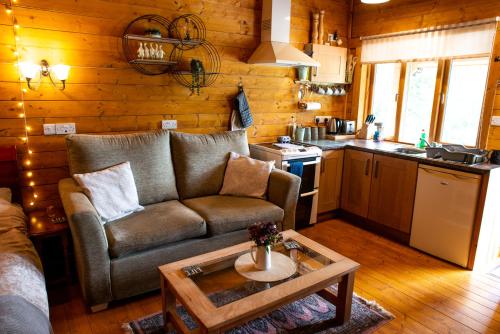 a living room with a couch and a table at Cherry Cabin - Little Log Cabin in Wales in Bettws Cedewain