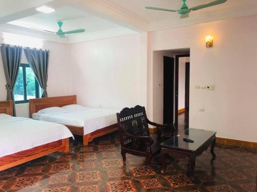um quarto com 2 camas, uma mesa e uma cadeira em Khách sạn Hoa Biển A em Xóm Côn