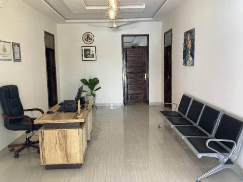 una oficina con escritorio y sillas en una habitación en Villa Nova Lodge, en Sogakofe