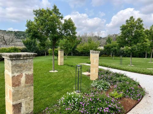 a garden with flowers and trees in a park at Villa Anna - Suites & Events in Specchia