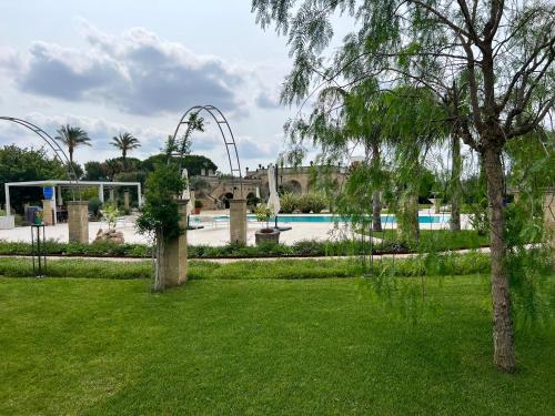 a park with a swimming pool and a tree at Villa Anna - Suites & Events in Specchia