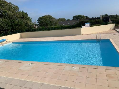- une grande piscine bleue revêtue de carrelage dans l'établissement Studio Blue Horizon vue mer, à Guidel-Plage