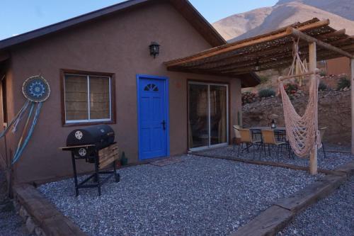 a house with a blue door and a hammock outside at Cumbres de Alcohuaz in Alcoguaz