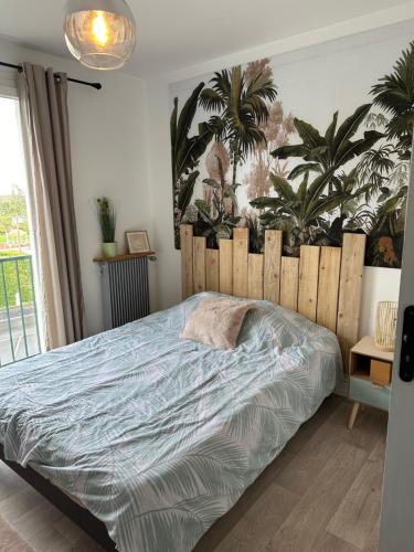 una camera con letto e testiera in legno di L’Etape berrichonne a Déols