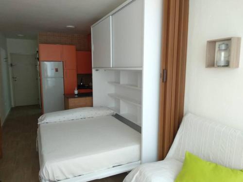 Cette petite chambre comprend deux lits et un réfrigérateur. dans l'établissement Estudio con acceso privado y directo a la Playa, à Isla Cristina
