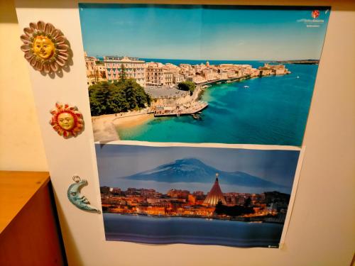 deux photographies d'une ville sur un mur dans l'établissement Sleep In Sicily, à Syracuse