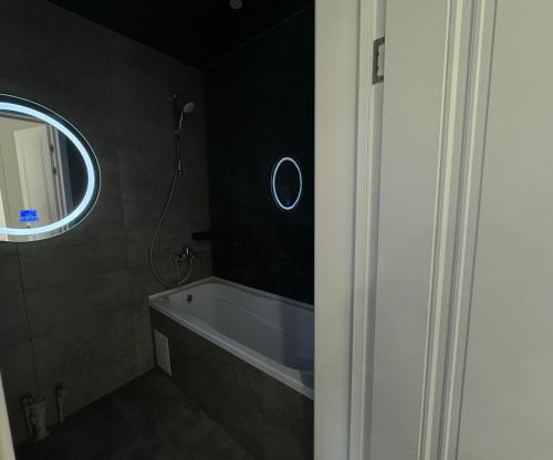 a bathroom with a bath tub and a mirror at ЖК Комсомольский in Taldykolʼ