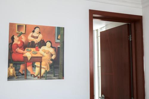 a painting of a group of women sitting at a table at Hotel Casa Botero 101 in Bogotá