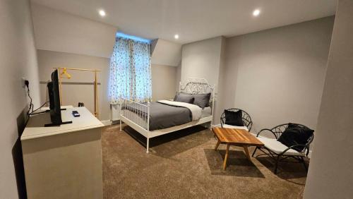 a bedroom with a bed and a desk and a television at Thames Ditton Surrey in Thames Ditton