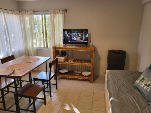 sala de estar con mesa y TV en Moreno Apart 2 en El Calafate