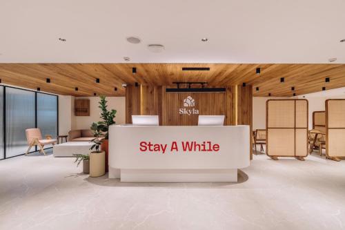 a lobby with a sign that says stay a while at SKYLA Studios & Suites - Kondapur in Hyderabad