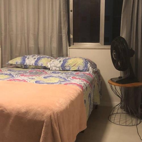 um quarto com uma cama e uma ventoinha ao lado de uma janela em Flat do lado Shopping Boa Vista no Recife