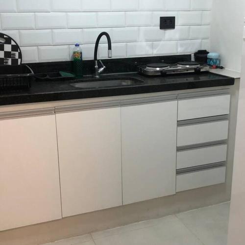 uma cozinha com armários brancos e um lavatório em Flat do lado Shopping Boa Vista no Recife