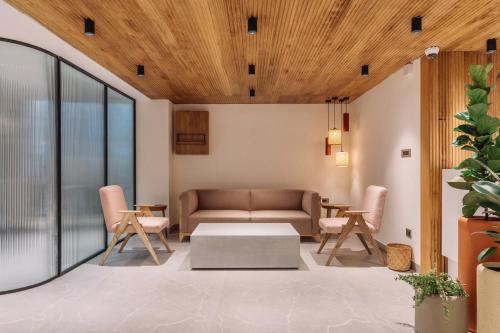 a living room with a couch and chairs at SKYLA Studios & Suites - Kondapur in Hyderabad