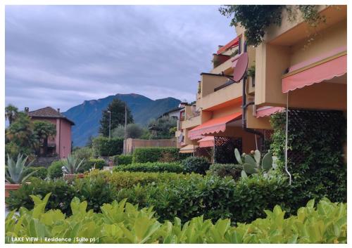 a row of buildings with mountains in the background at LFSUITE LuganoLake Terrazza Spiaggia privata Parking WI-FI Netflix in Porlezza
